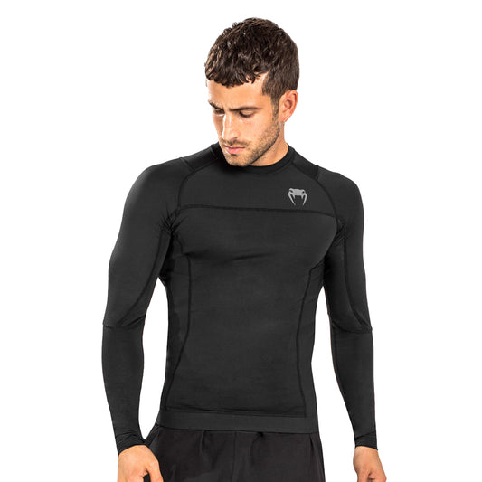 Venum G-Fit Air Long-Sleeve Rashguard. Paidassa on venumin logo vasemmassa rinnassa. Kuvassa rashguard kuvattuna miehen päällä. ptcumbat.com