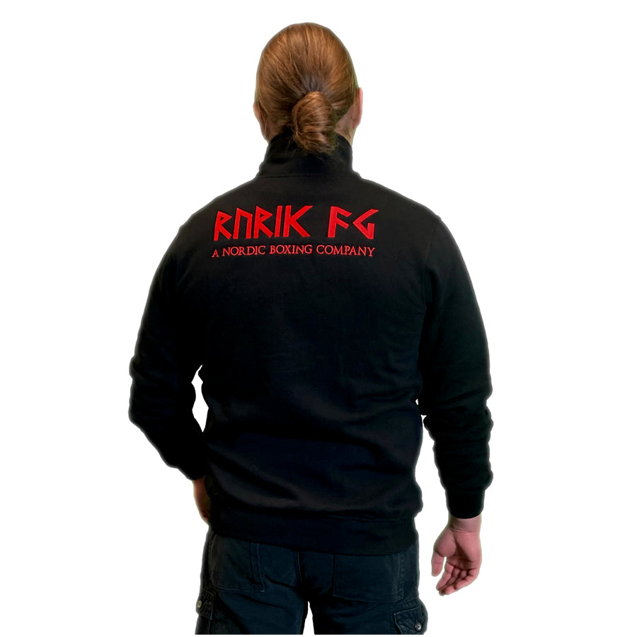 Rurik Fightgear korkeakauluksinen, vetoketjullinen takki. Brodeerattu logo rinnuksessa. Takki on valmistettu Euroopassa. Takki kuvattuna takaa Mikan päällä. PT-Combat - 100% suomalainen Rurik-asiantuntijasi!