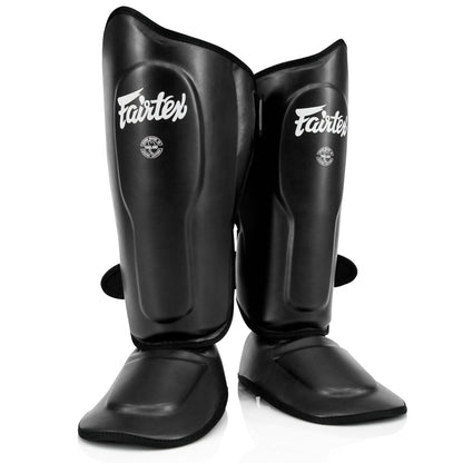 Fairtex SP9 -säärisuojat tarjoavat ylivoimaista suojaa ja mukavuutta. Fairtexin säärisuojat kuvattu edestä, mustat. 