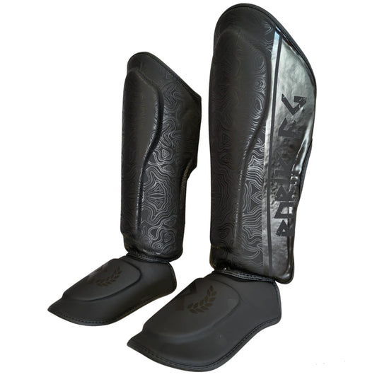 Rurik Fightgear Grimnir säärisuojat on suunniteltu thainyrkkeilyyn ja potkunyrkkeilyyn. Ergonominen muotoilu, tehokas iskunvaimennus ja kestävät kiinnitykset. kuvassa sääritukipari viistosti. 