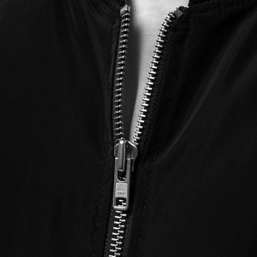 Rurik Fightgear-lentäjänpusakka.
Rurik FG "R" -logo rintapielessä sekä riimulogo selässä monivärisesti brodeerattuna. Kuvassa vetoketju. ptcumbat.com