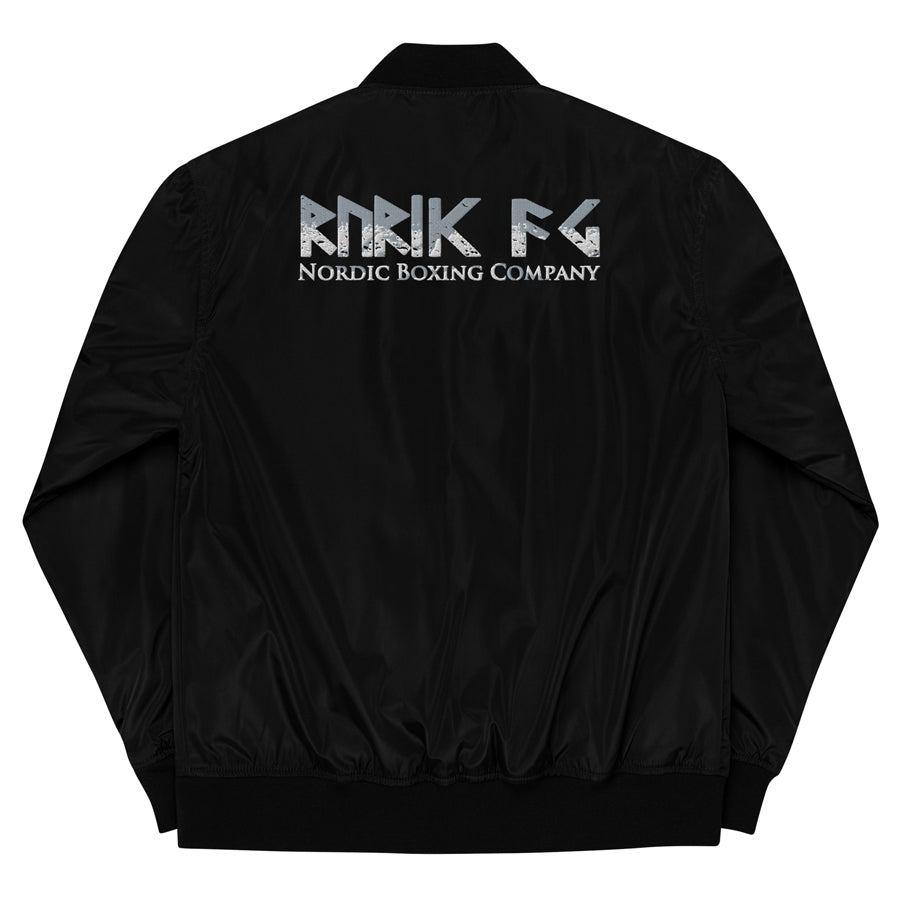 Rurik Fightgear-lentäjänpusakka.
Rurik FG "R" -logo rintapielessä sekä riimulogo selässä monivärisesti brodeerattuna. Kuvassa pilottitakki  takaa. ptcumbat.com