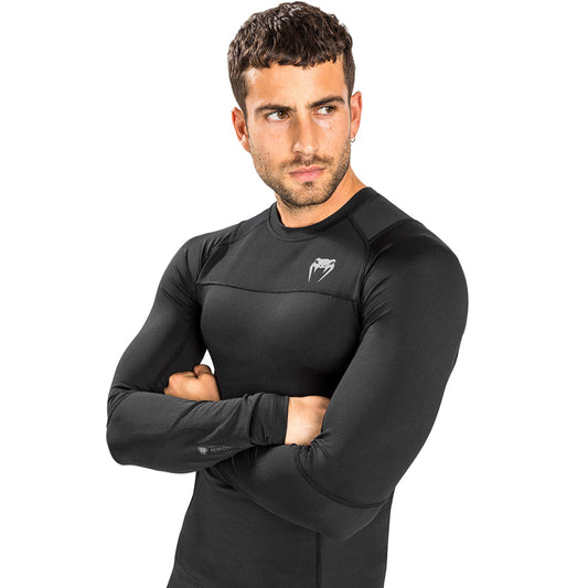 Venum G-Fit Air Long-Sleeve Rashguard. Tyylilkäs musta väri. Kuvassa rashguard kuvattuna miehen päällä. ptcumbat.com